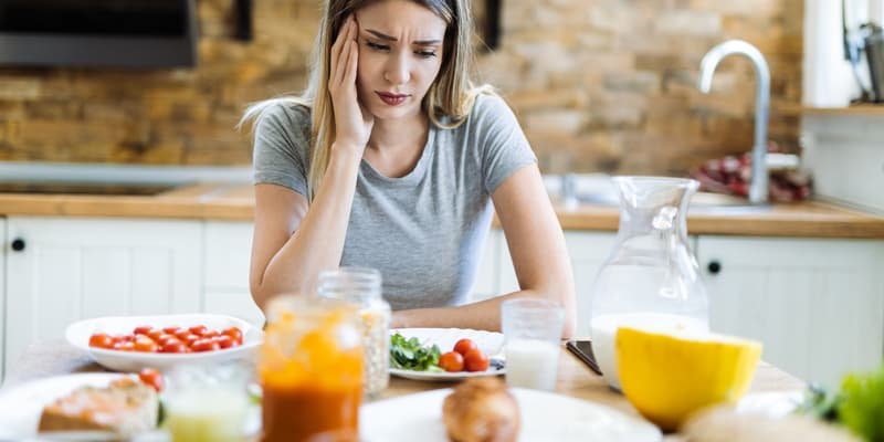 kobieta przy posiłku - czy to objawy nietolerancji pokarmowej?