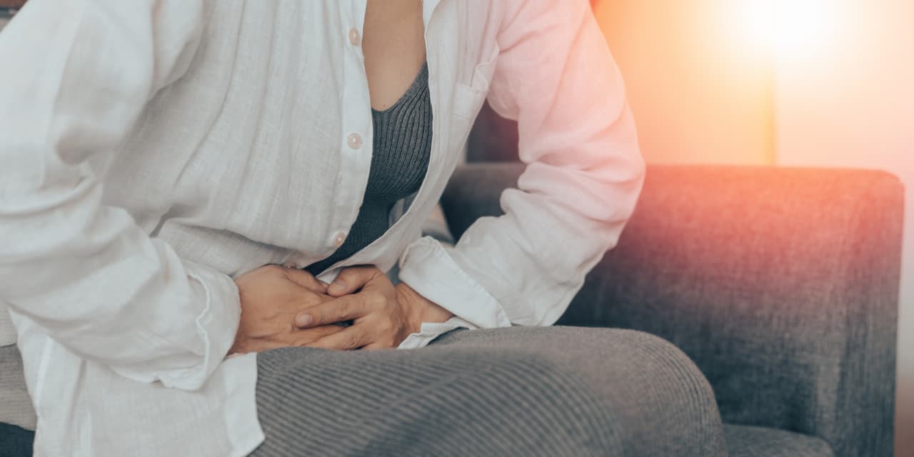 Zapalenie narządów miednicy mniejszej - objawy, przyczyny oraz metody leczenia. Kobieta trzyma się za bolące podbrzusze.